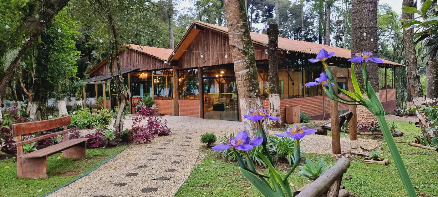 Jardim florido com caminho de pedra até o salão