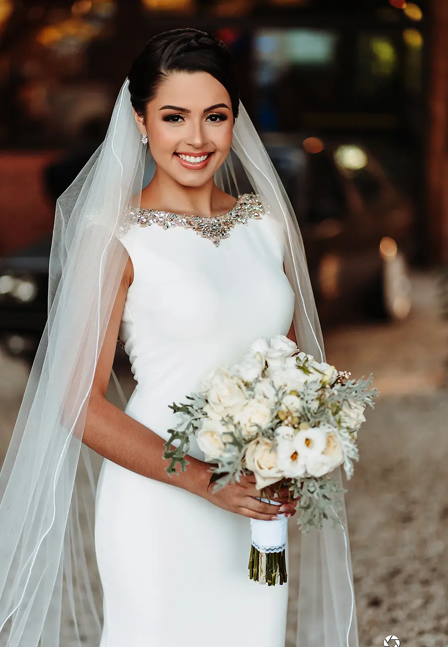 Noiva sorrindo com o buquê de flores brancas