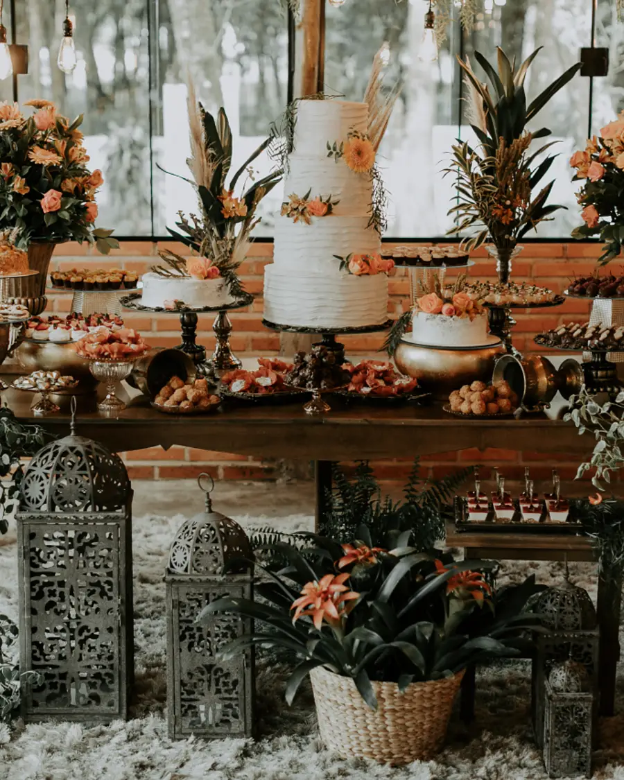 Mesa de doces e bolo decorada com flores